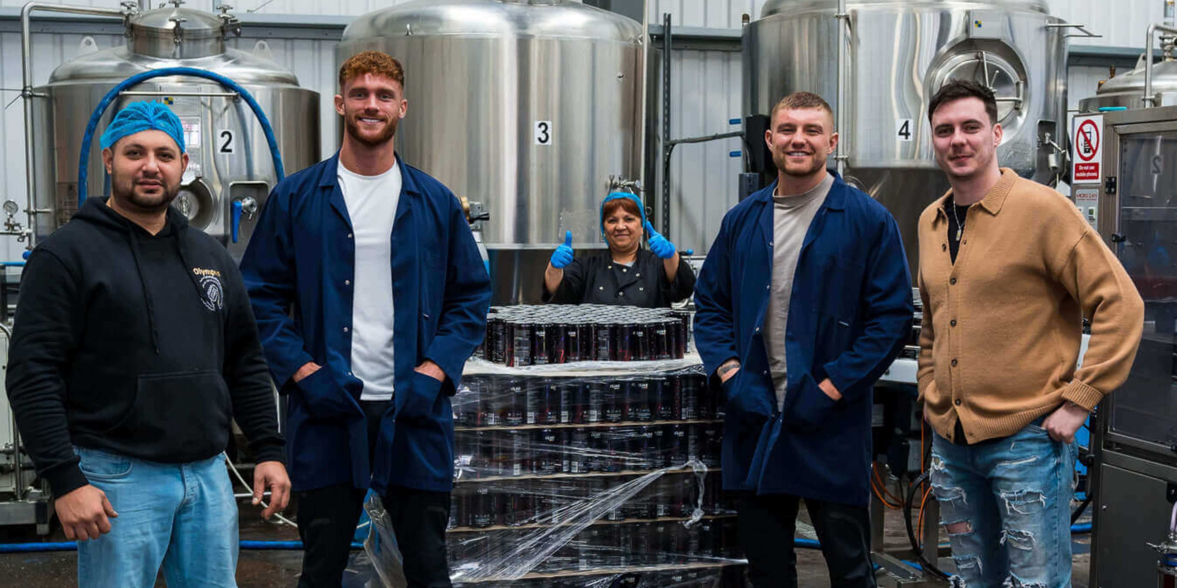 Elixr founders stood in factory next to cans of Elixr